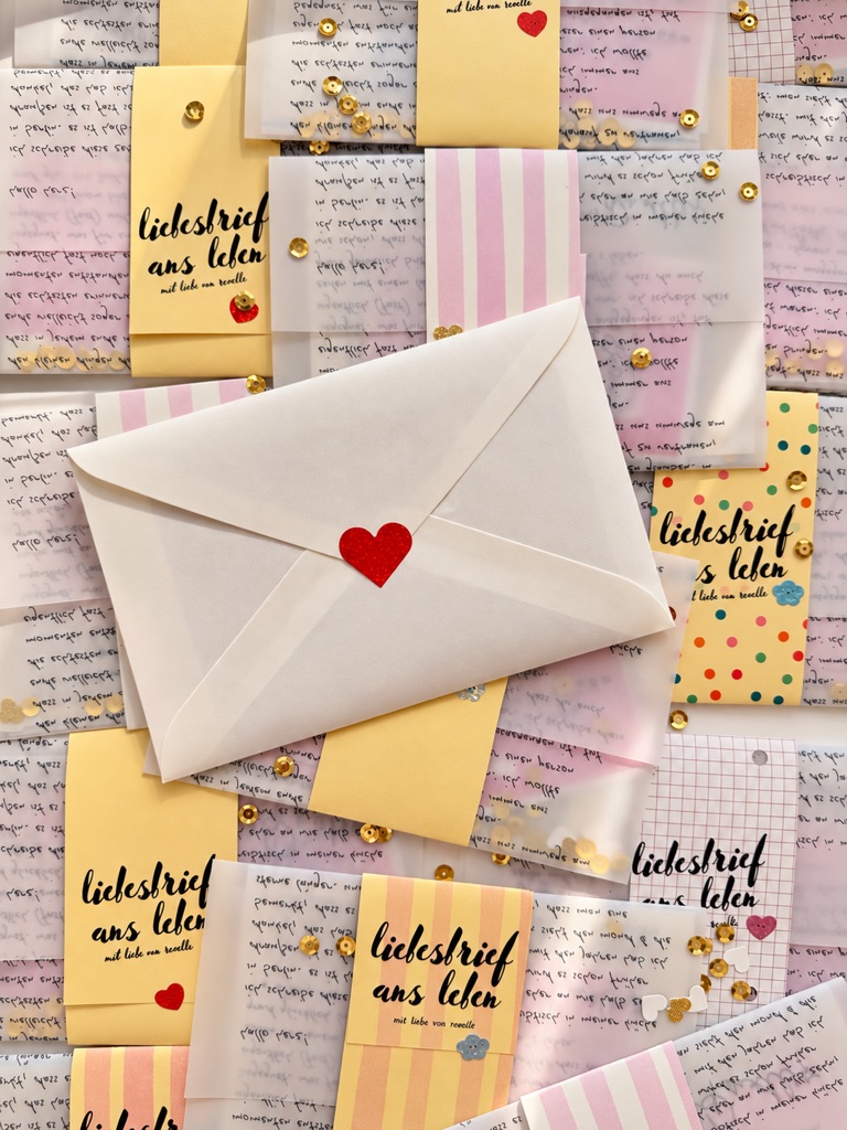 umschläge, pergamentpapier und banderolen mit der aufschrift liebesbrief ans leben